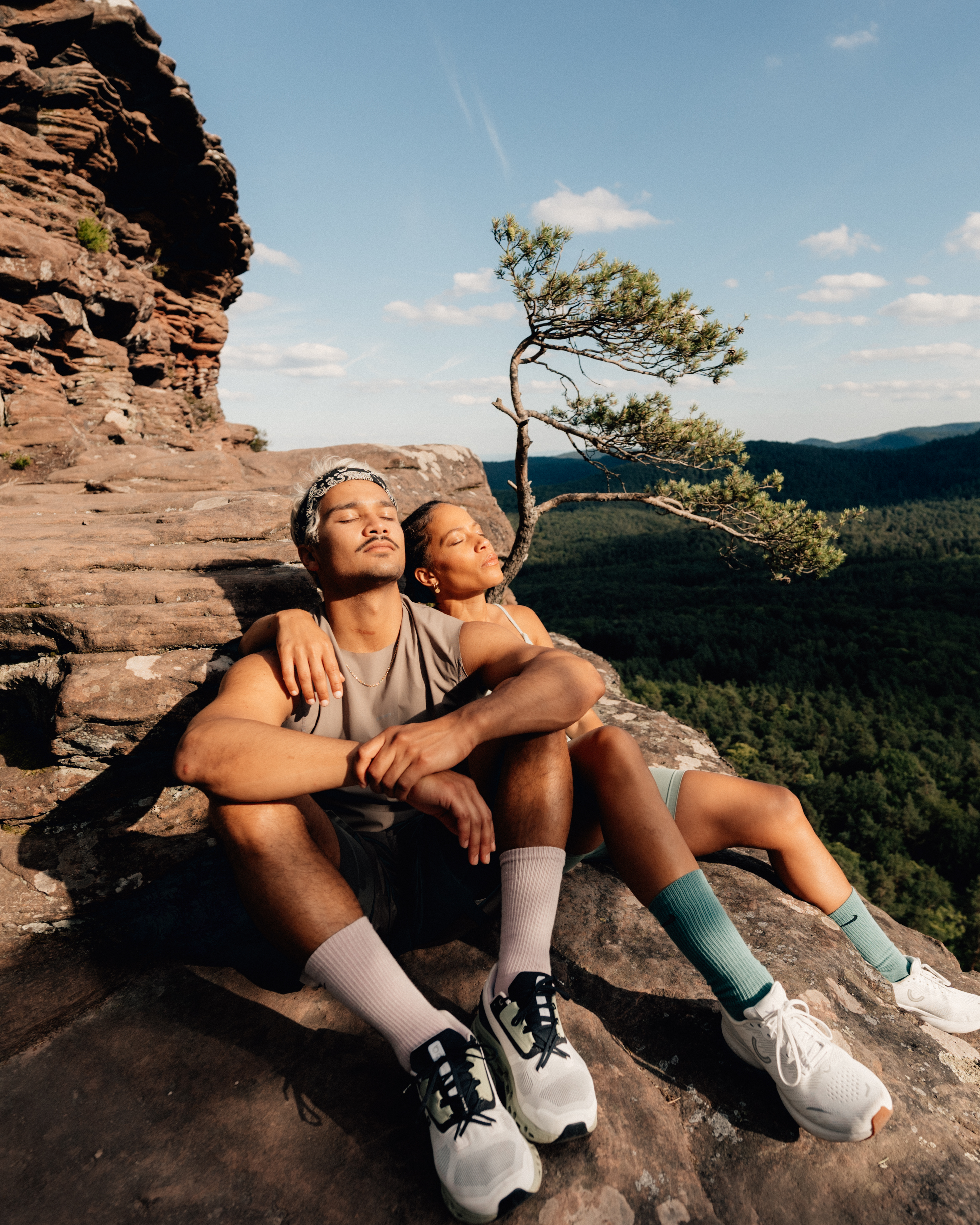 couple sitting on top of rock after trail run